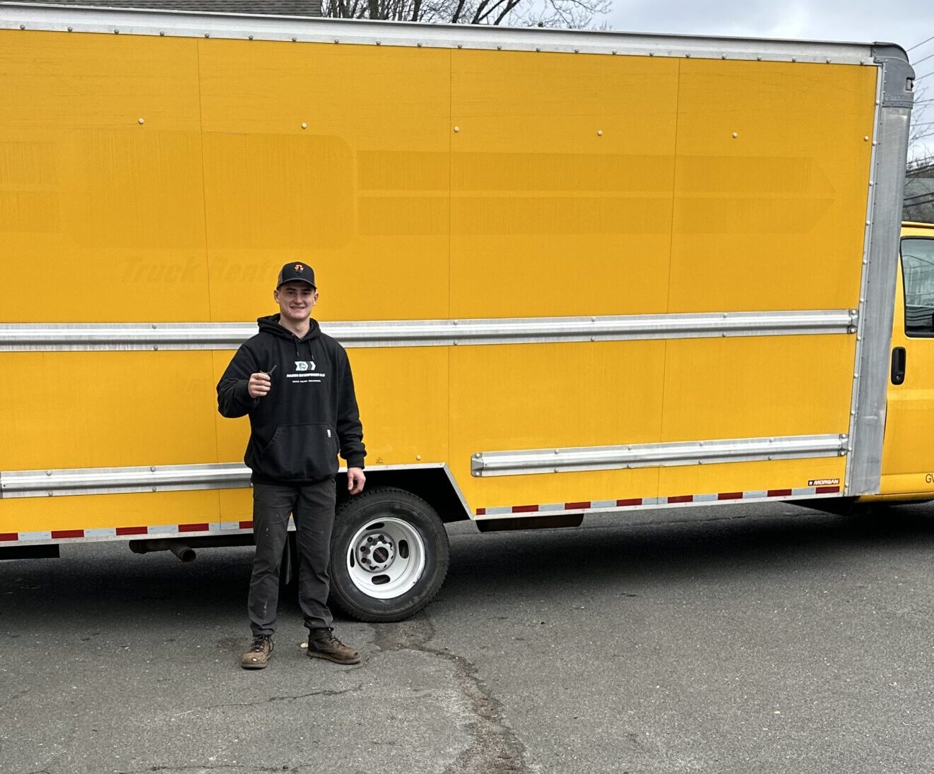 Tanner Marsh standing in front of his truck giving a thumbs up to the camera
