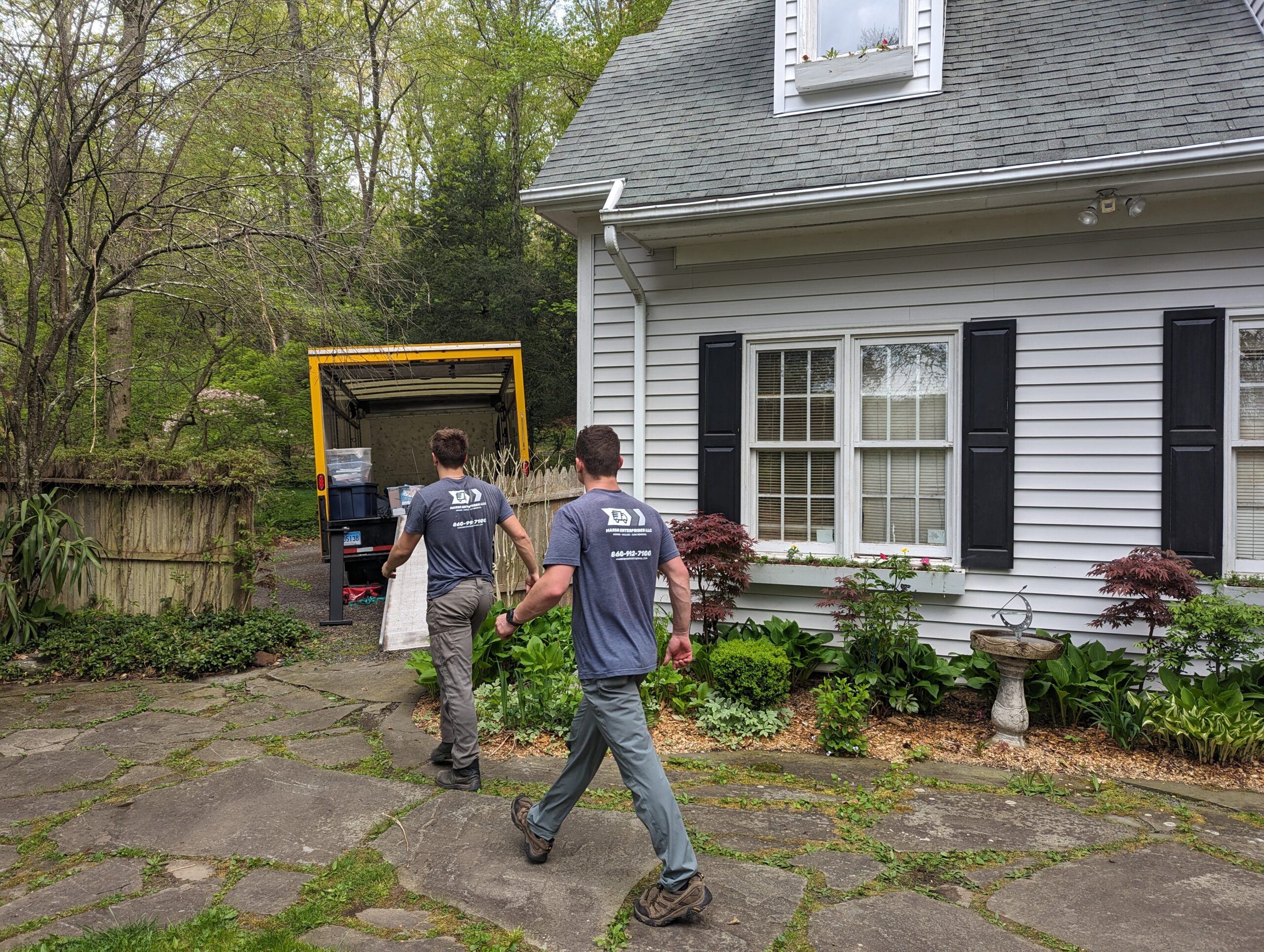 Two men walking towards a truck to haul more things